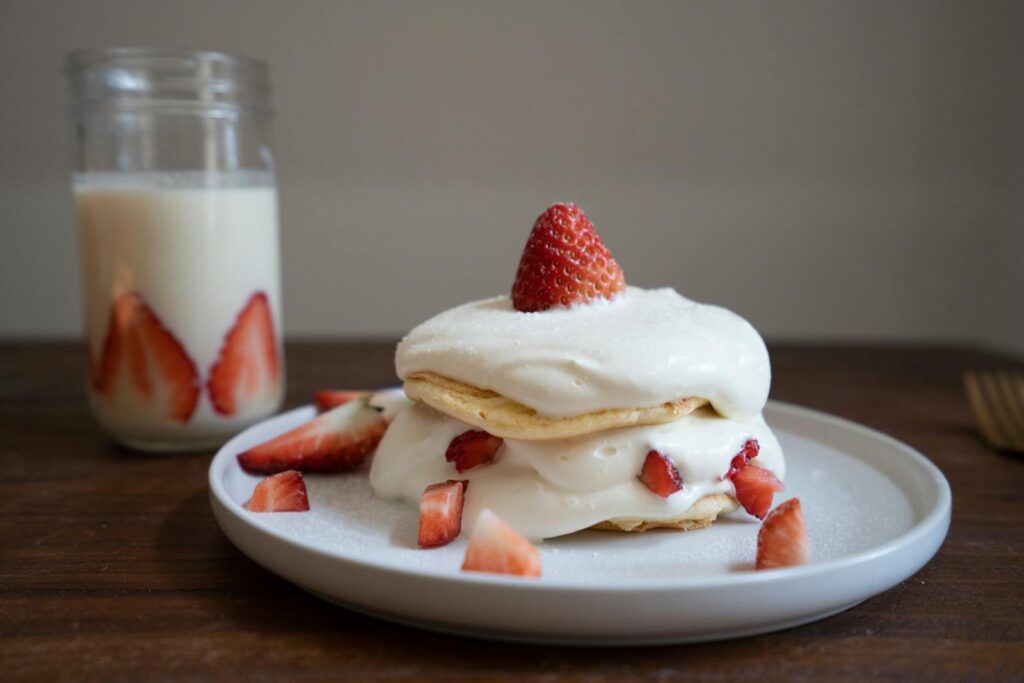 Close-up of a strawberry shortcake with whipped cream and fresh strawberries.