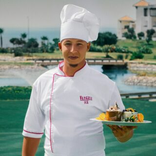woman in white chef uniform holding green plate with food