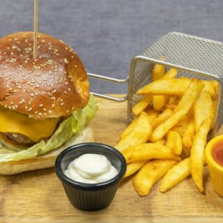 burger and fries on brown wooden chopping board