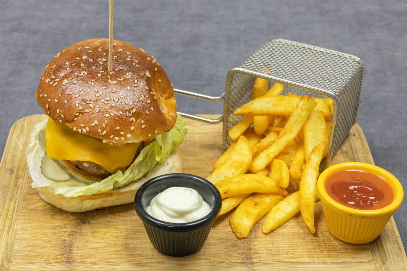 burger and fries on brown wooden chopping board