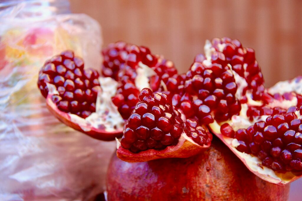 a pomegranate is sitting on a table next to a bag