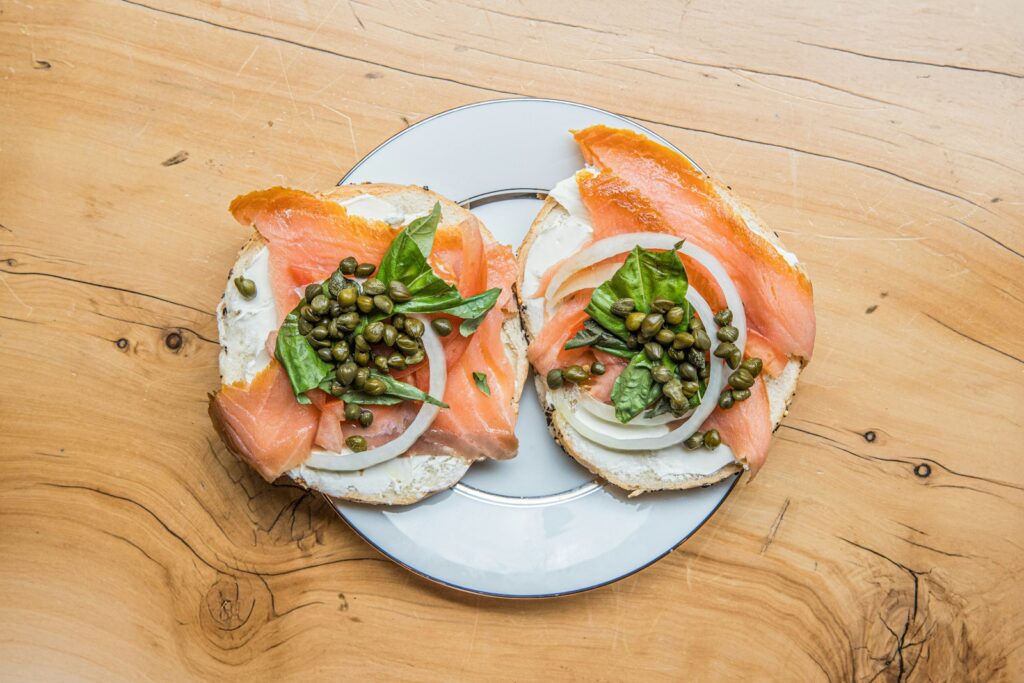 A white plate topped with two sandwiches covered in toppings