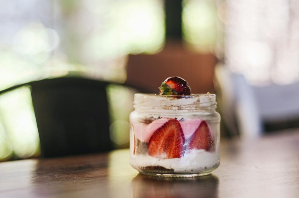 Indulge in a creamy strawberry delight beautifully presented in a rustic jar.