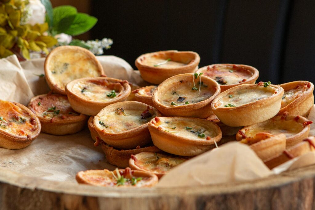 A close-up of freshly baked mini quiches, perfect for party appetizers.