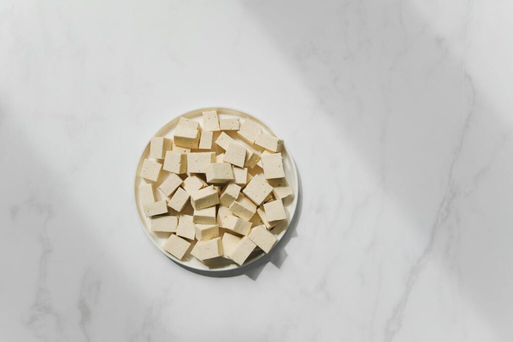 Top view of cubed tofu on a white plate, perfect for culinary projects