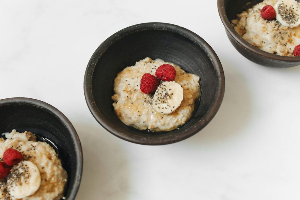 Delicious oatmeal bowls topped with fresh banana, raspberries, and chia seeds.
