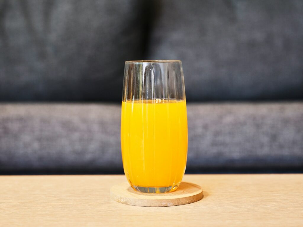 a glass of orange juice sitting on a table
