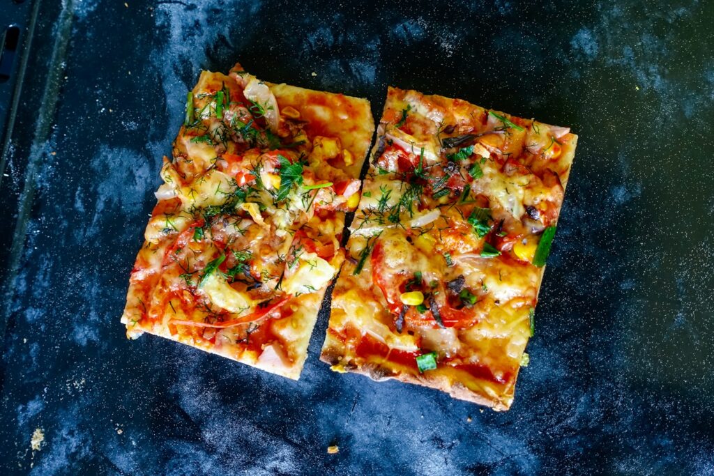 pizza with green and brown sauce