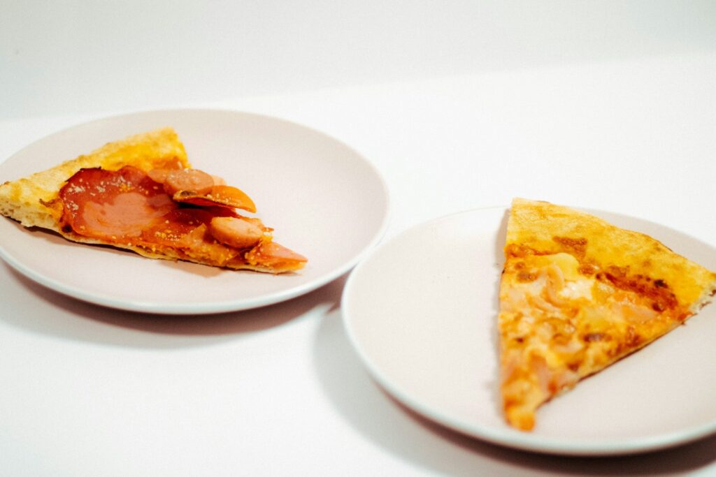 two white plates with slices of pizza on them