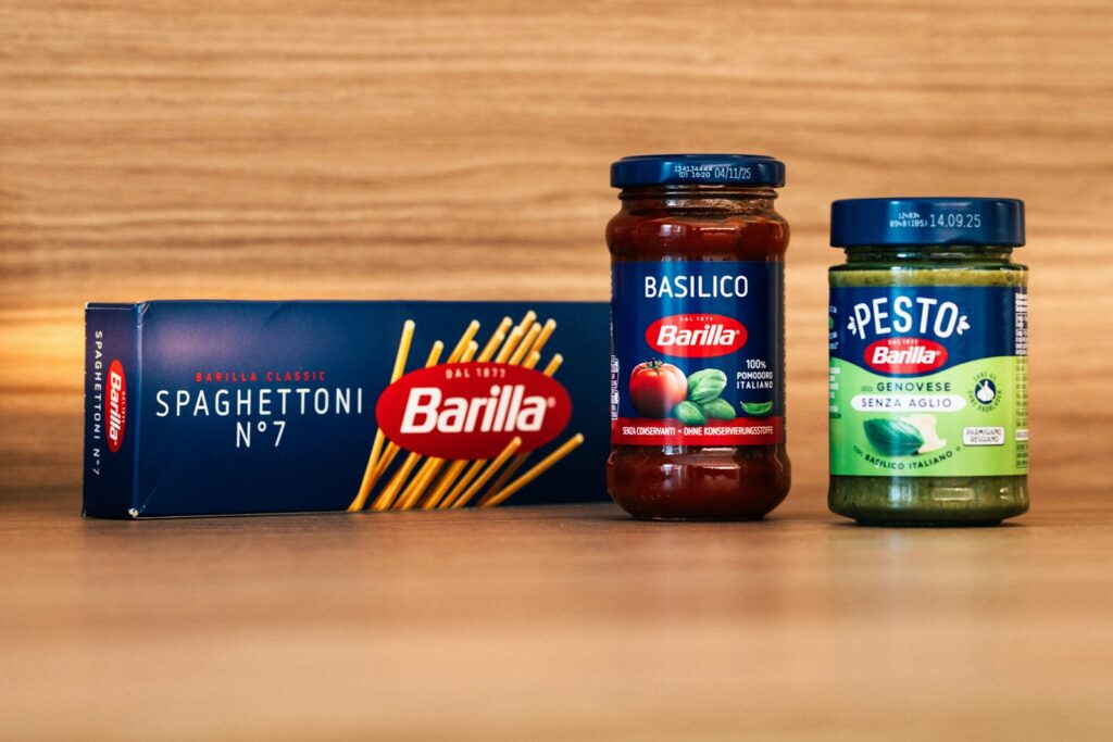 two jars of pasta sauce next to a box of pasta sauce