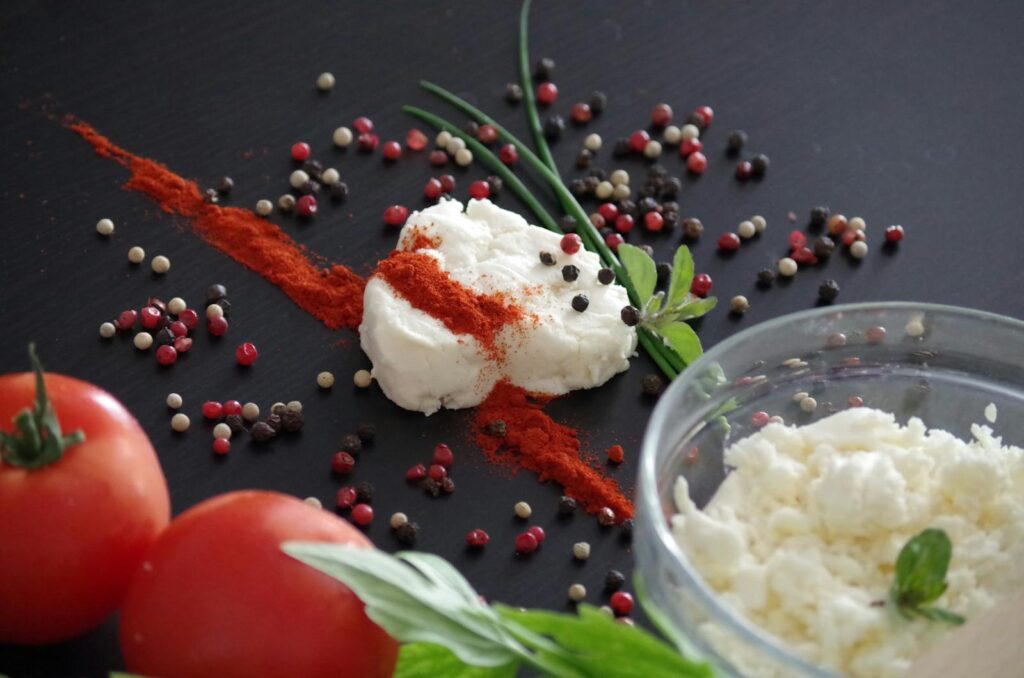 Close-up of traditional Slovak bryndza cheese garnished with herbs, spices and tomatoes, perfect for culinary stock photos.