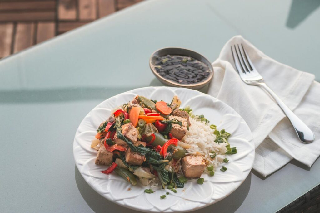 Delicious vegan tofu stir fry with mixed vegetables served on a white ceramic plate.