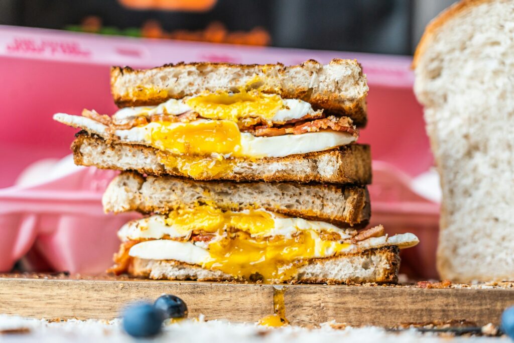 a stack of toasted sandwiches with eggs and cheese