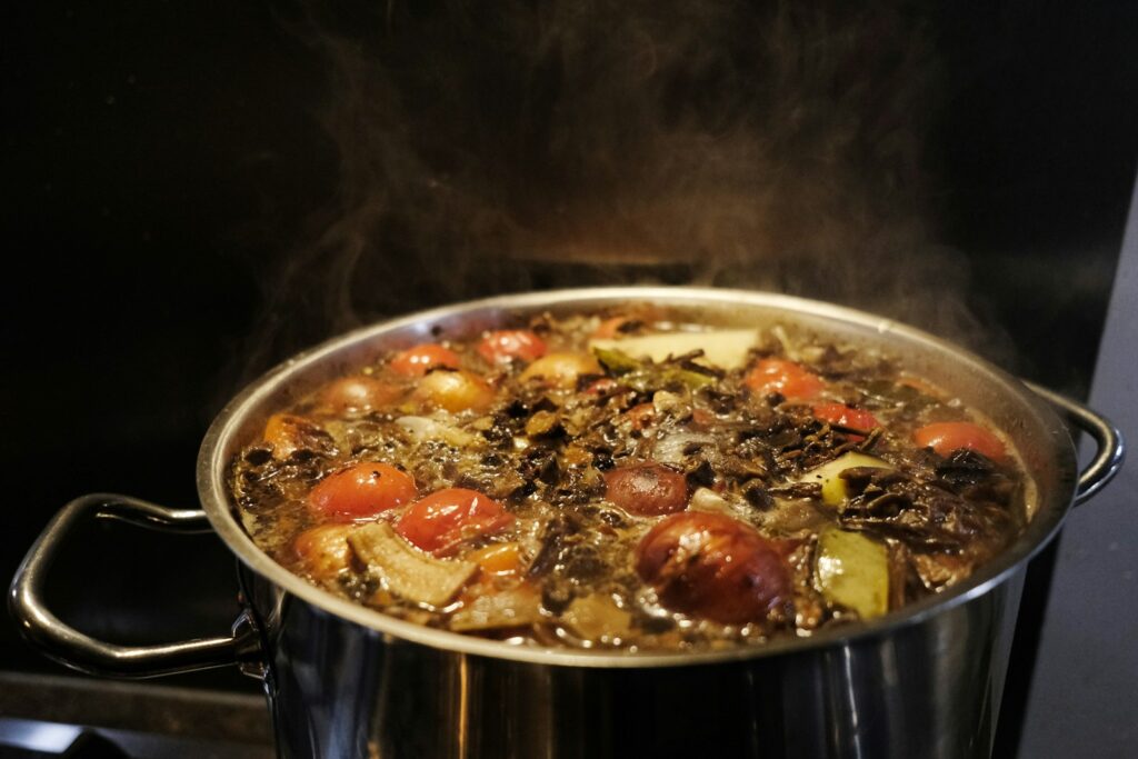 Soup is simmering in a large pot.