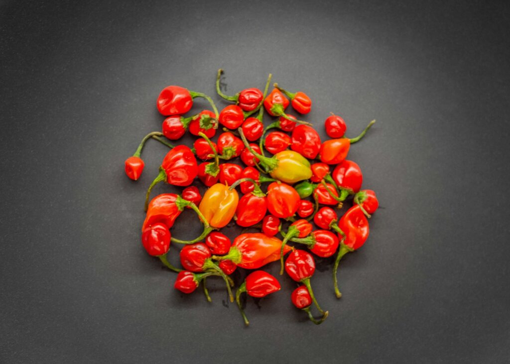 a pile of red and yellow peppers on a black surface