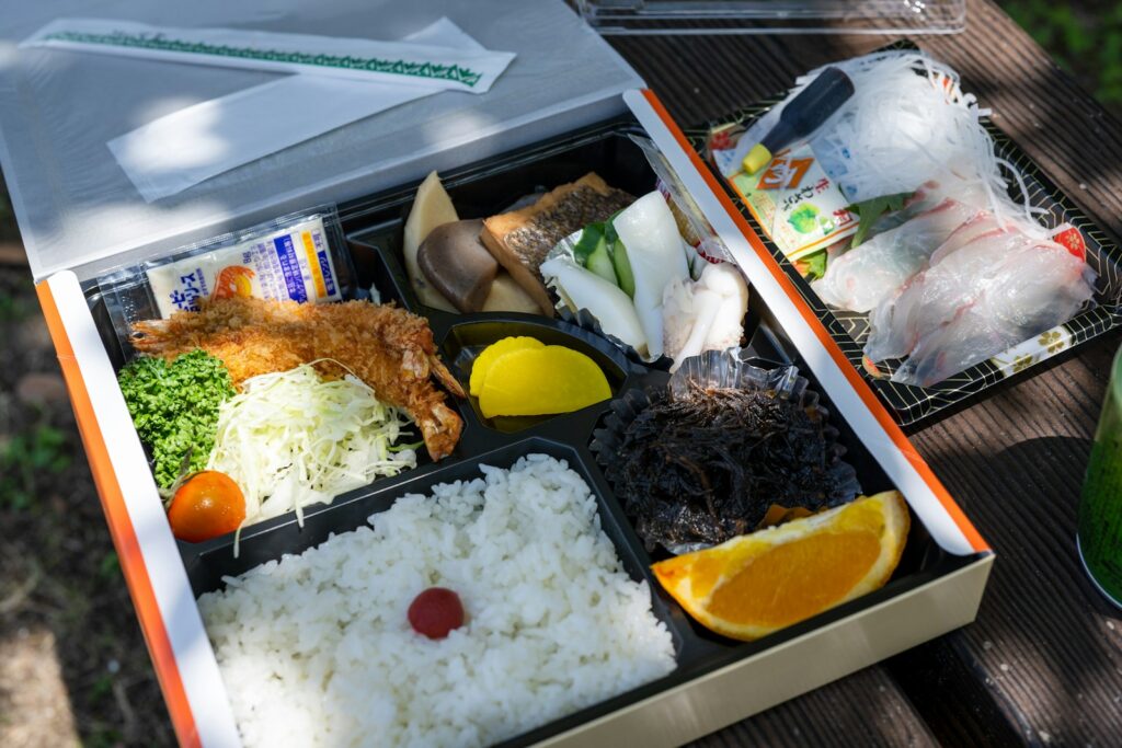 a lunch box with rice, meat, and vegetables